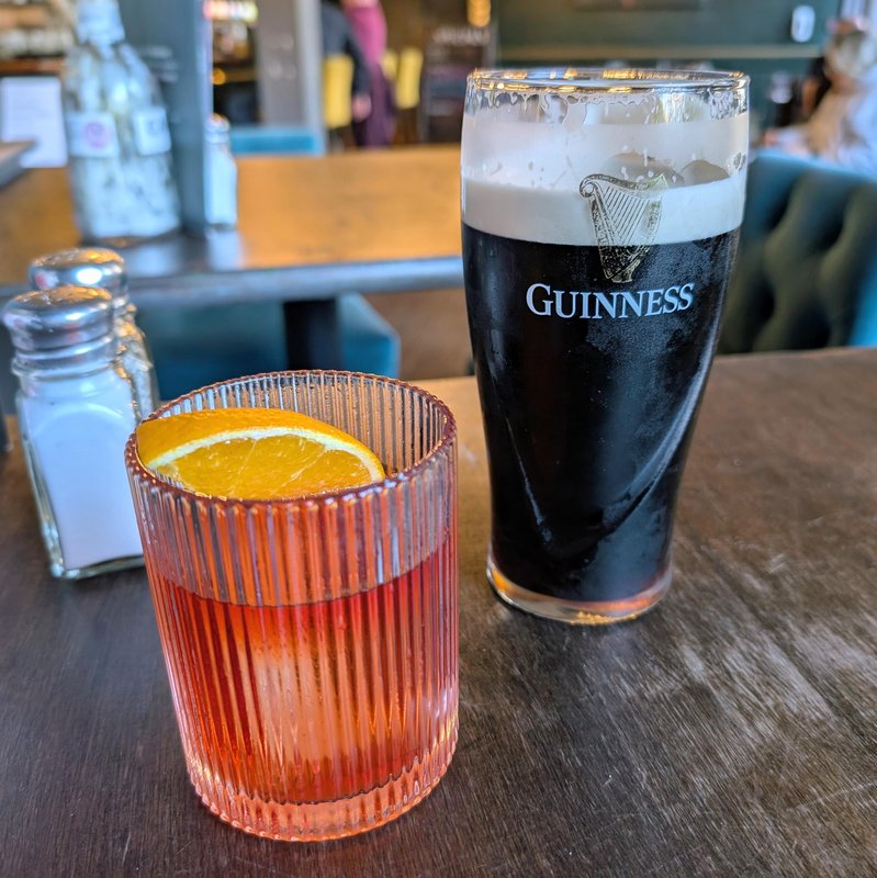 Photo of a cocktail and a Guinness 