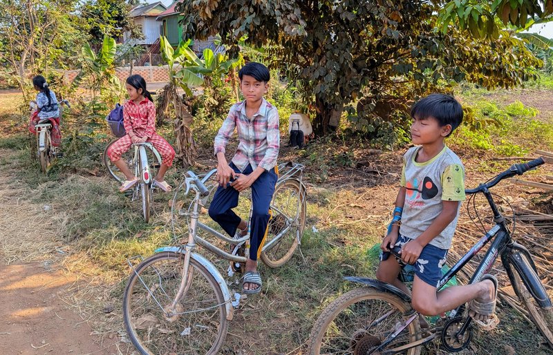Smiling kids on the roadside with their bikes