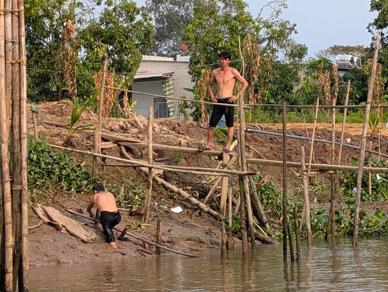 Two men working by the side of the canal
