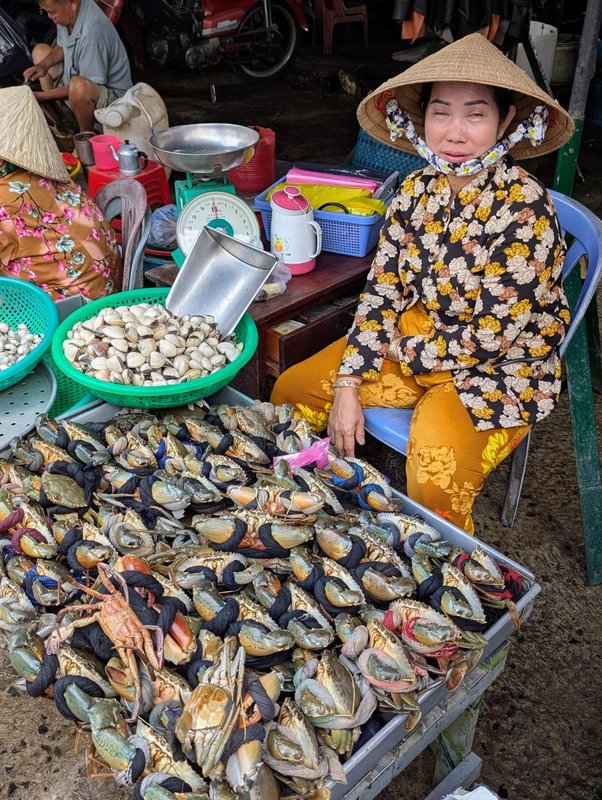 Crab seller, her shirt pattern matches the crabs she is selling